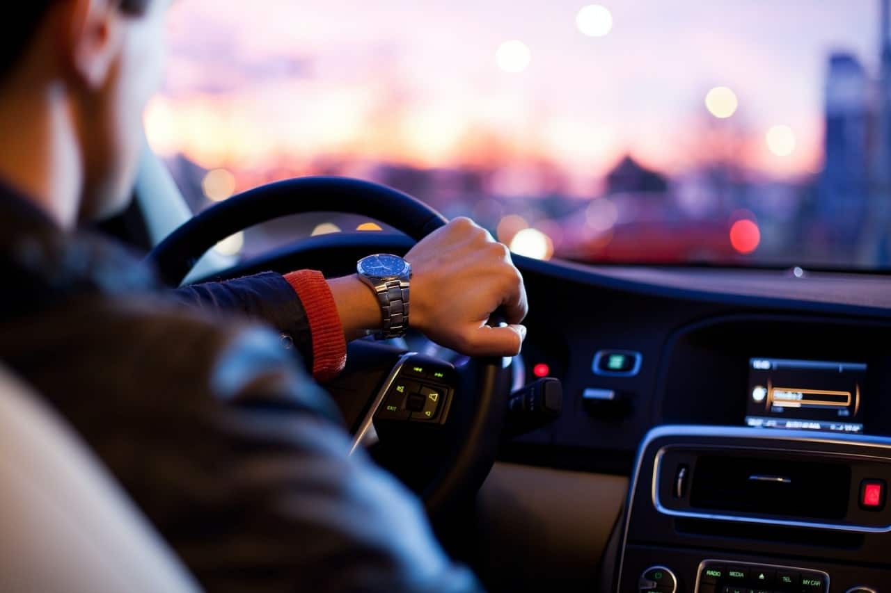A man driving at night, his hand on the steering wheel, emphasizing the importance of safe driving.