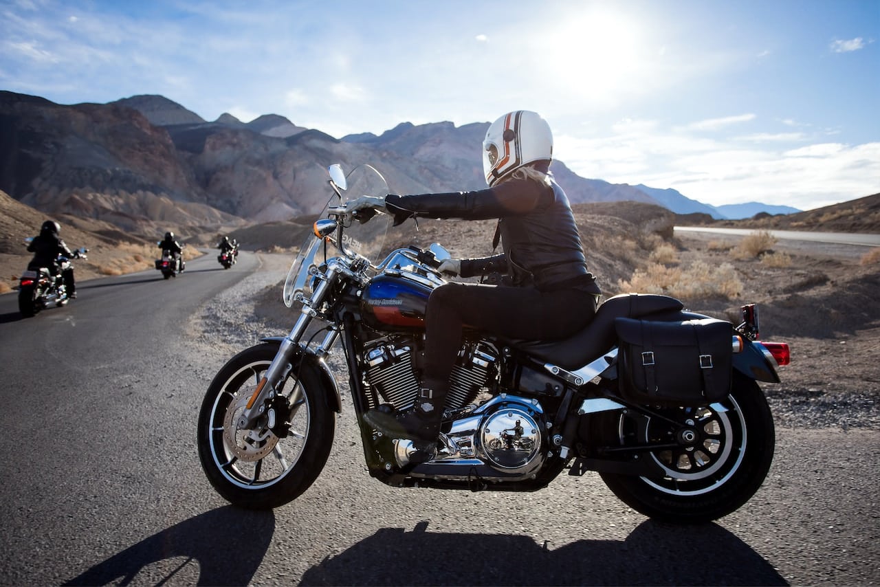 A person riding a motorcycle on a desert road, symbolizing the risks associated with motorcycle accident lawsuits.