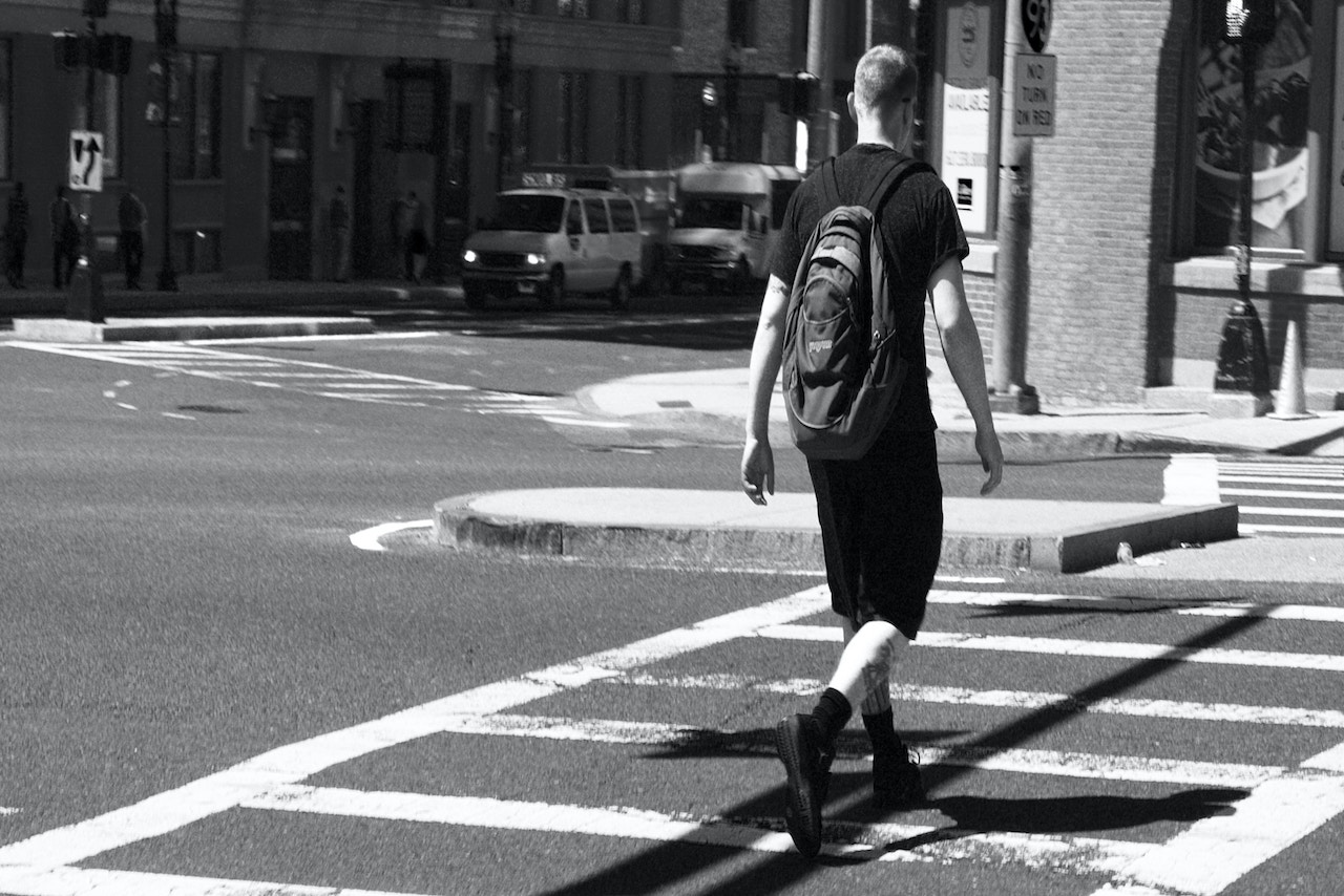 A man safely crossing a city street, highlighting pedestrian safety in Rancho Cucamonga accident claims.