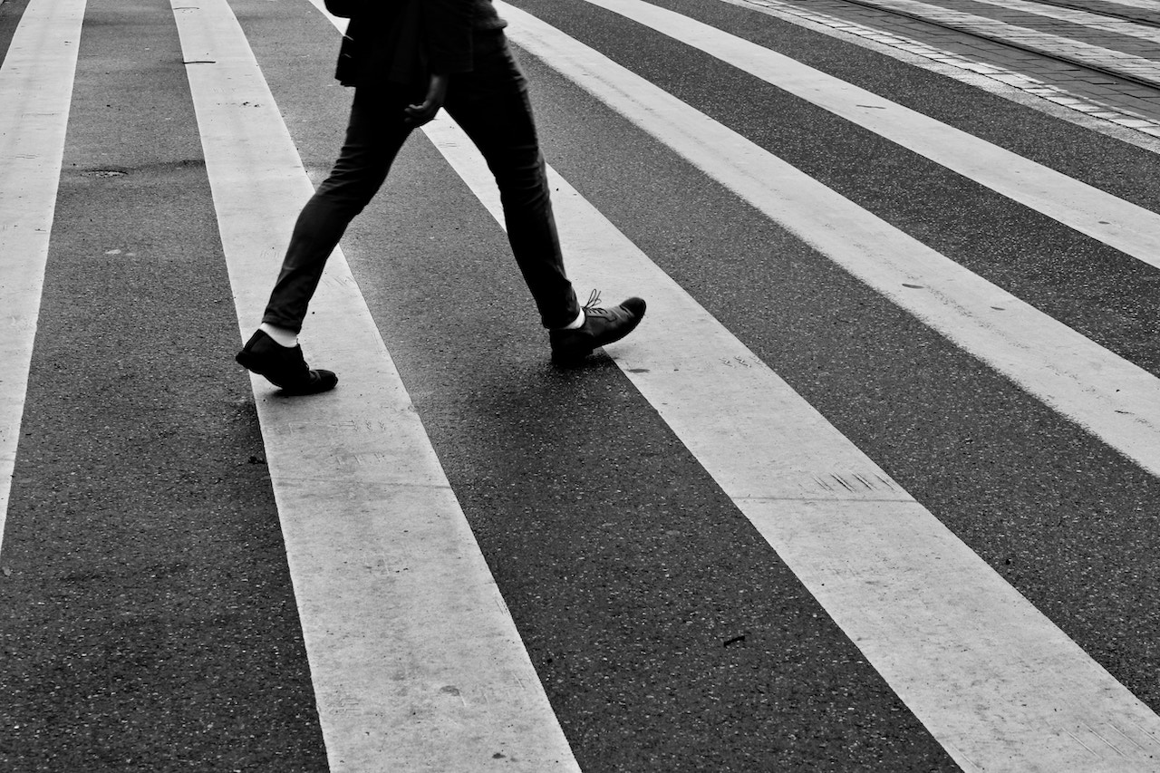 An individual navigates a crosswalk in the street, reflecting on pedestrian safety issues in Rancho Cucamonga.
