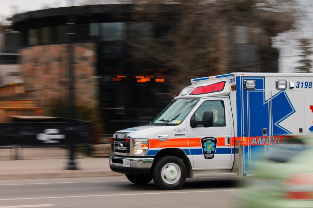 A white and blue ambulance on standby, highlighting its role in addressing common injuries from transportation accidents in Rancho Cucamonga.