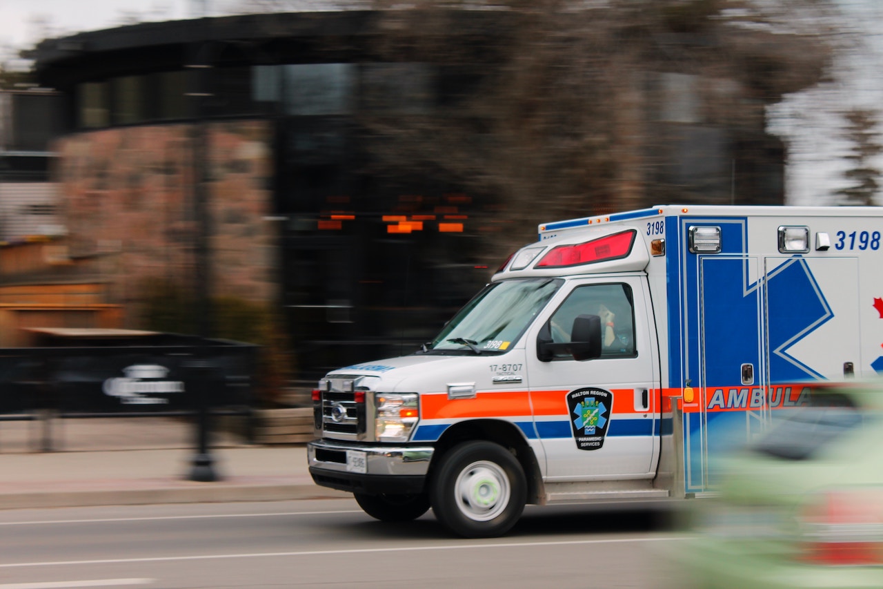 A white and blue ambulance on standby, highlighting its role in addressing common injuries from transportation accidents in Rancho Cucamonga.