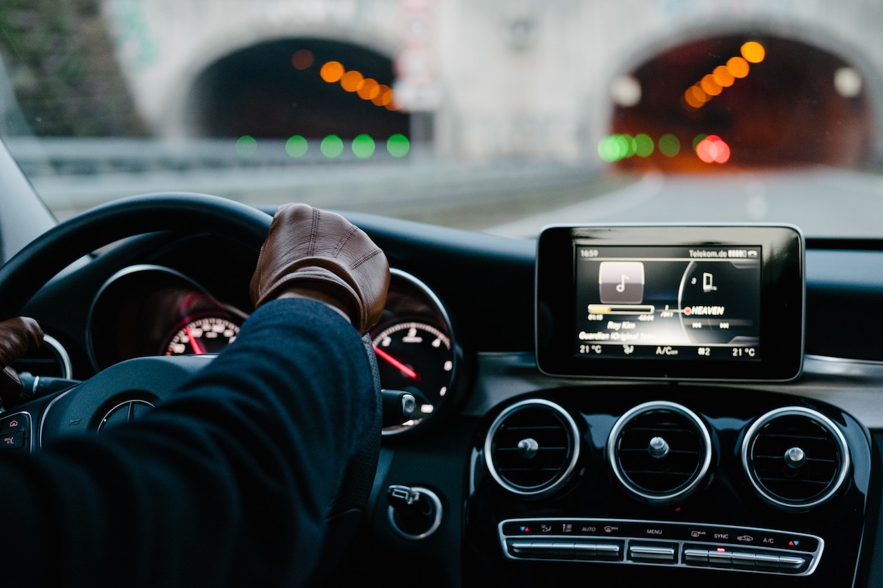 A man behind the wheel with a tablet on the dashboard, illustrating the issue of drowsy driving accidents in Rancho Cucamonga.