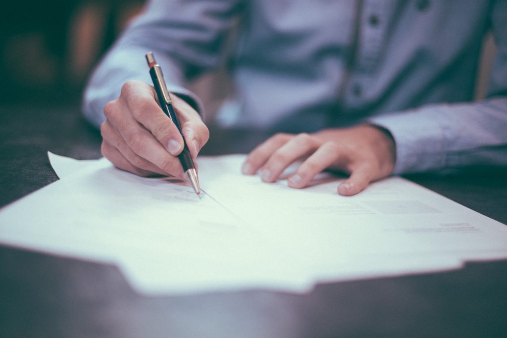 A person writes on paper with a pen, illustrating the documentation phase of a personal injury case in Rancho Cucamonga.