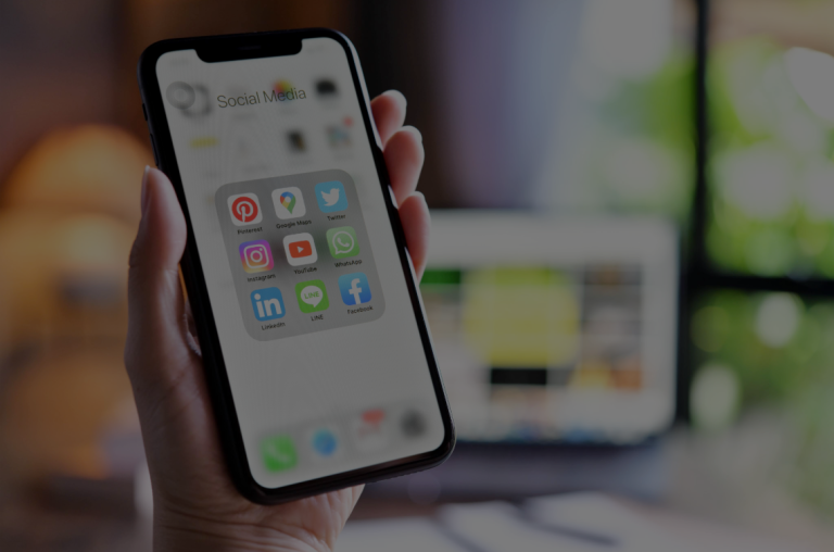 Hand holding a smartphone with social media app icons, illustrating how posts can affect California personal injury claims.