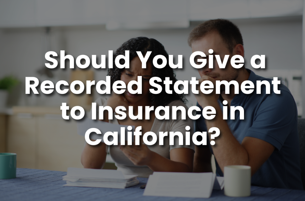 Worried couple reviewing insurance paperwork at home, used as a header image for a blog about recorded statements after a California accident.